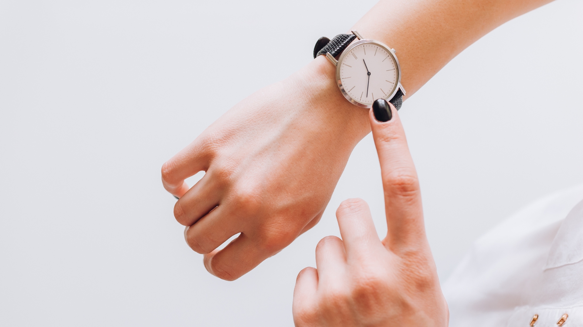 person pointing to the clock on their wrist