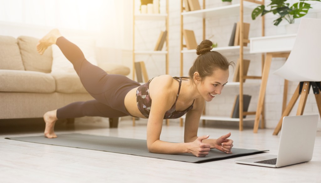woman smiling doing yoga in room