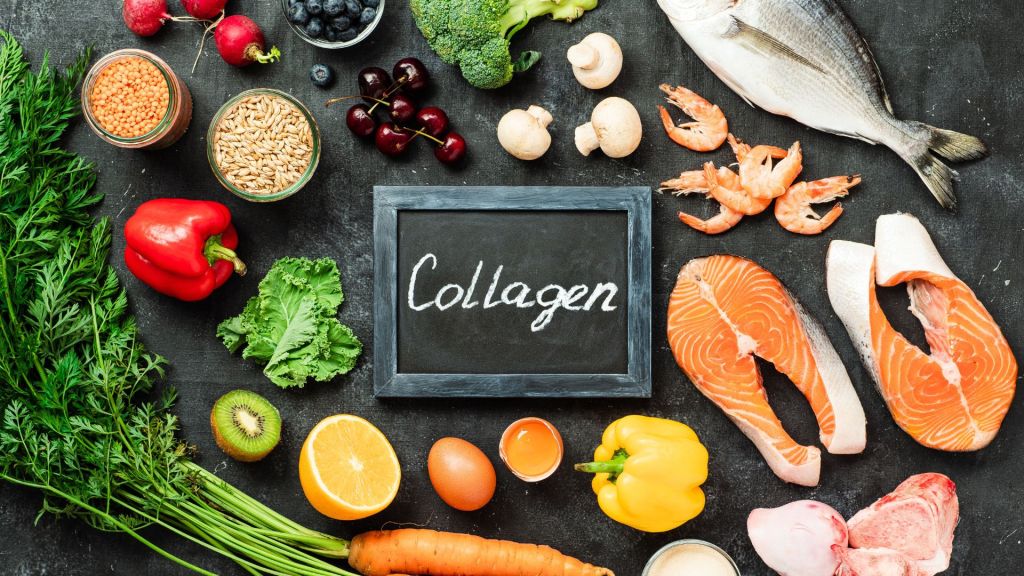 Various healthy foods like salmon, shrimp, vegetables, fruits, grains, and an egg arranged around a chalkboard with "Collagen" written on it.