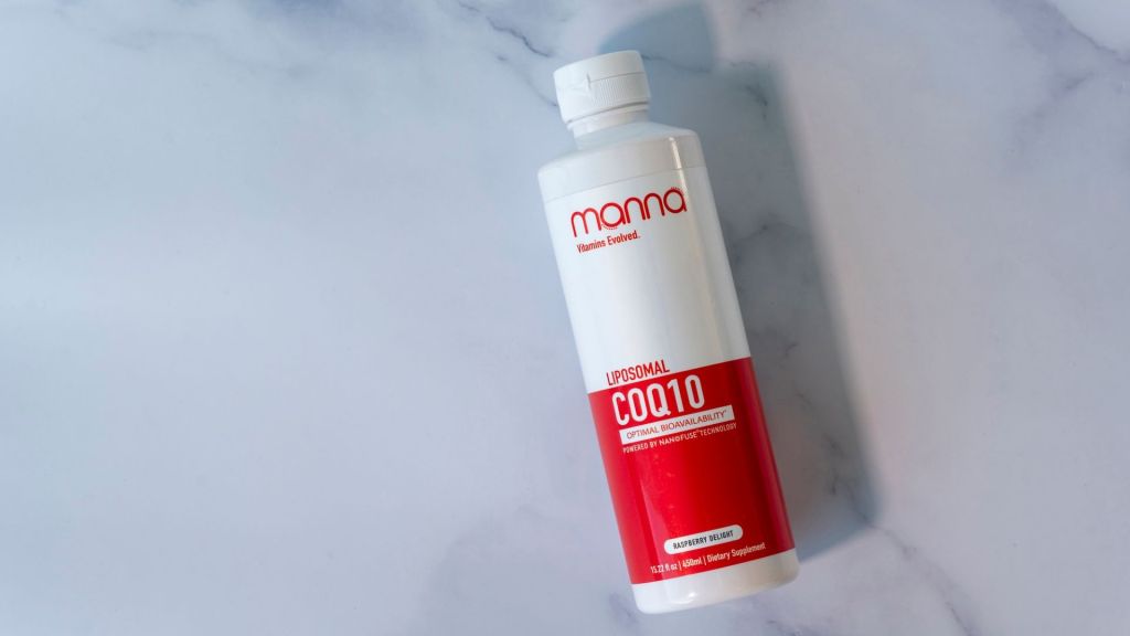 A bottle of Manna Liposomal COQ10 on a marble surface. The bottle is white with a red and white label.