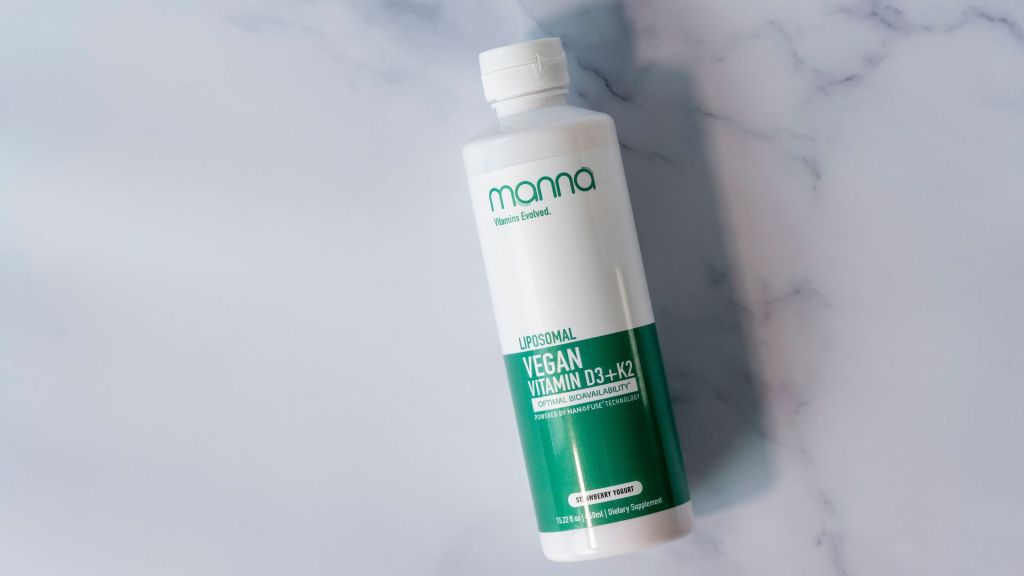 Bottle of Manna Liposomal Vegan Vitamin D3+K2 on a marble surface.