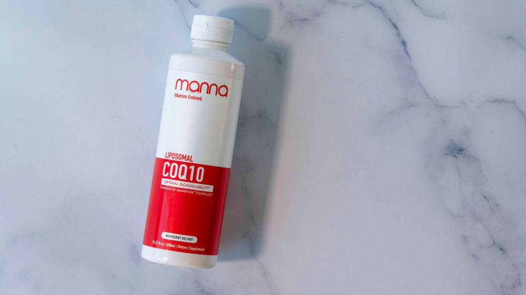 A white and red bottle labeled "Liposomal COQ10" by "manna." The bottle is on a white marble surface.