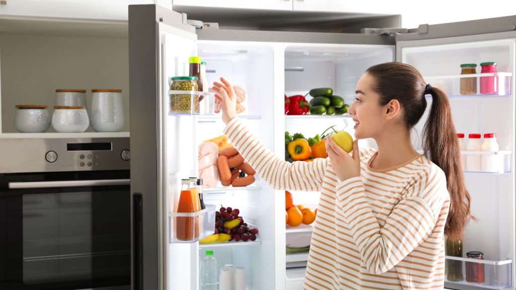 woman taking food out of fridge.