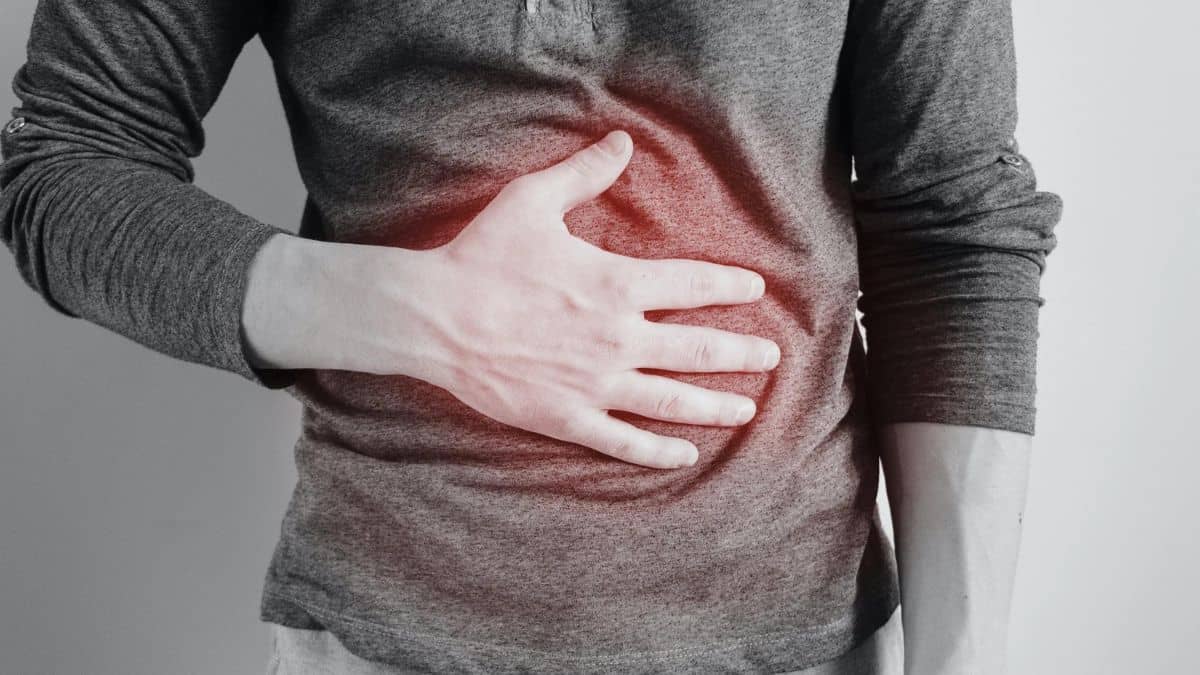 Person clutching their chest in pain, possibly indicating heartburn or cardiac discomfort.