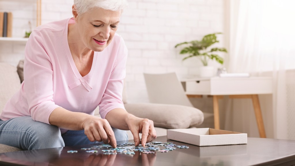 elderly woman doing a puzzle