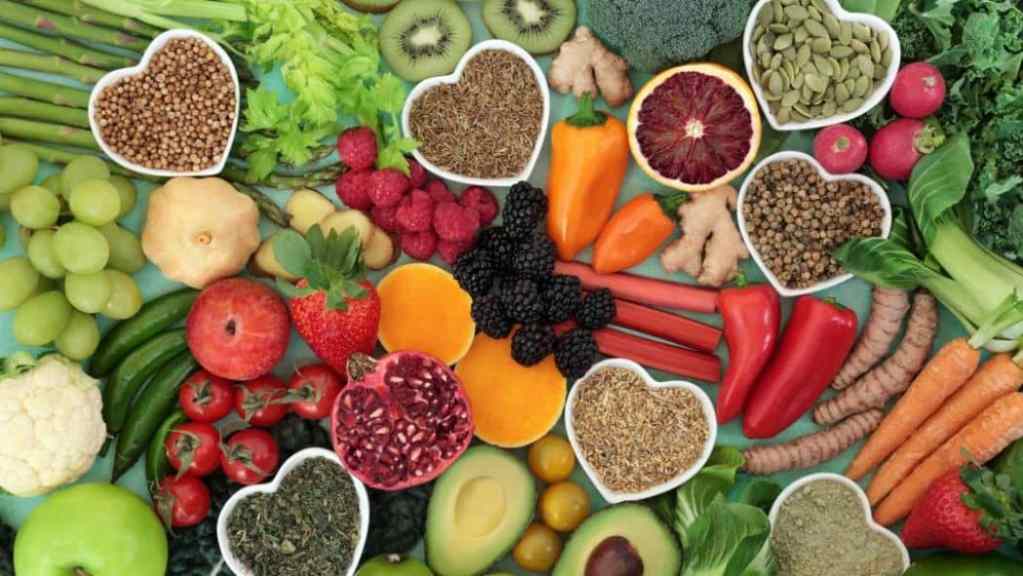 A vibrant assortment of fruits, vegetables, and grains arranged to represent a heart-healthy diet.