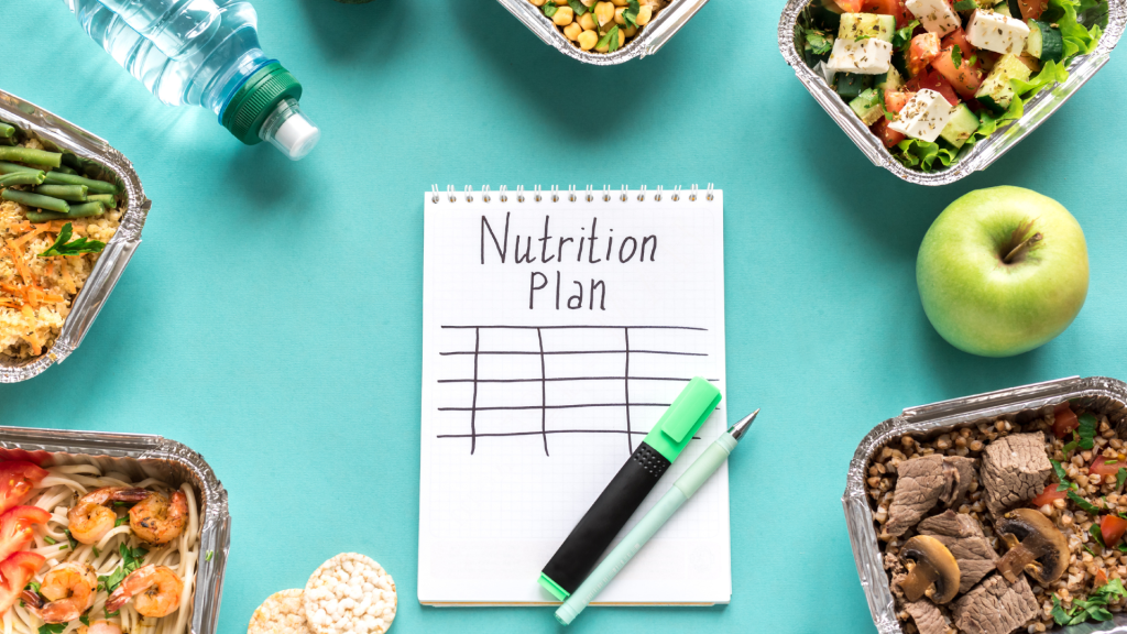a notepad with nutrition plan written as the headline, surrounded by prepped meals
