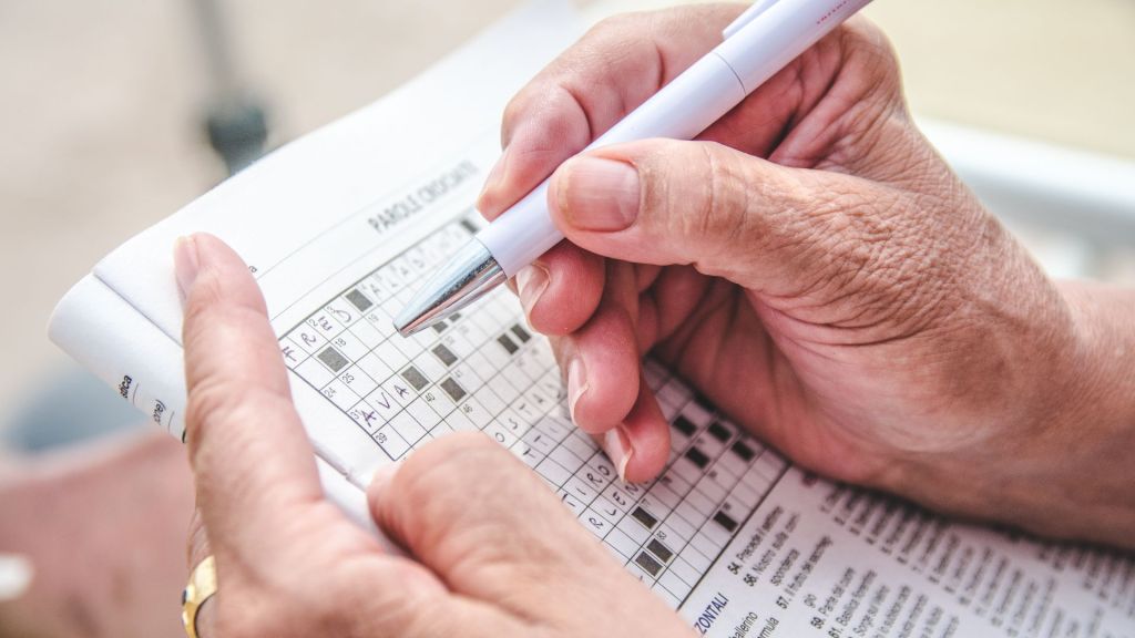 person completing a crossword puzzle
