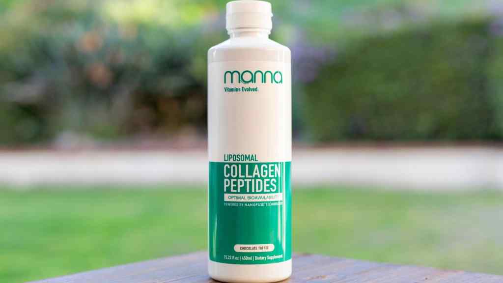 Bottle of Manna Liposomal Collagen Peptides dietary supplement on an outdoor surface, with a garden blurred in the background.