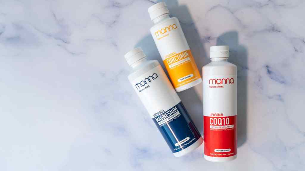 Three bottles of supplements on a marble surface, labeled Magnesium, Curcumin, and CoQ10.