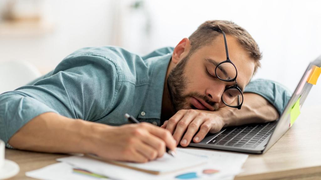 Man asleep on top of a laptop