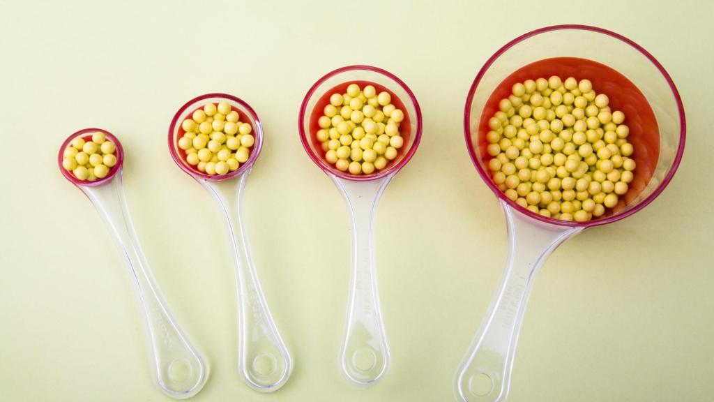 Four different spoon sizes filled with beads to show different serving sizes.