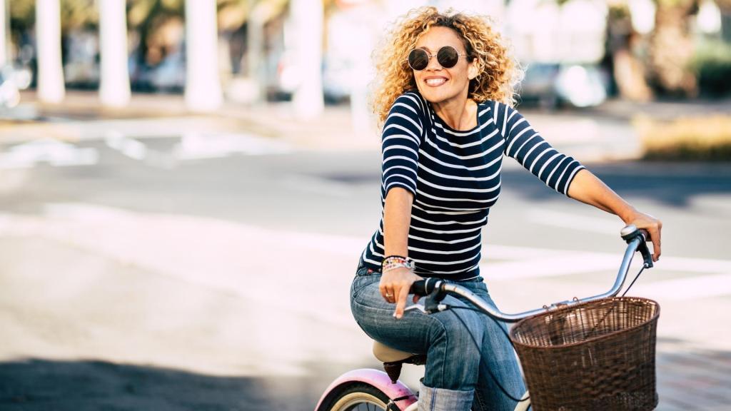 Happy woman in sunglasses riding a bike