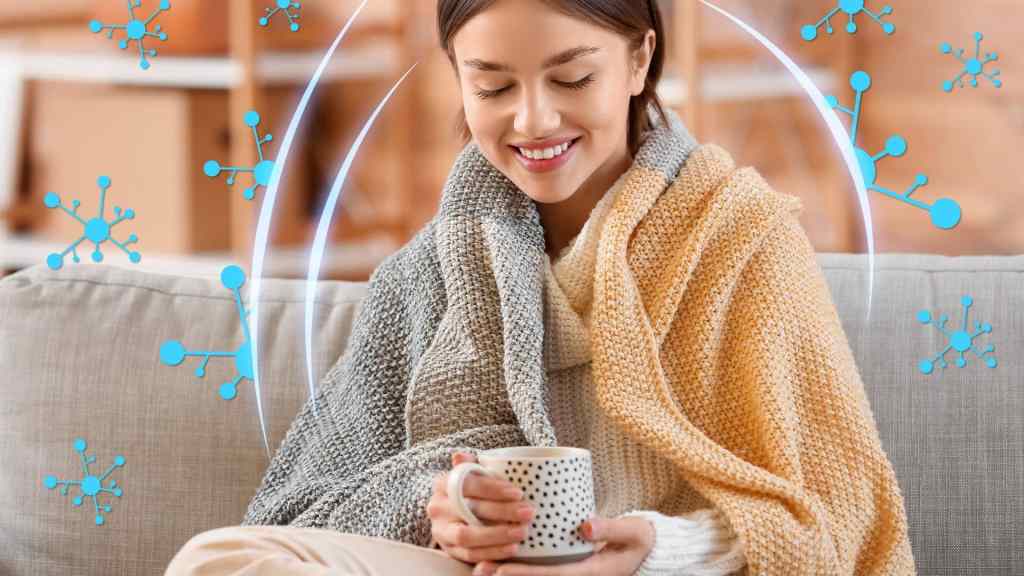 Woman wrapped in blankets holding a mug on a sofa, surrounded by blue abstract molecule designs.