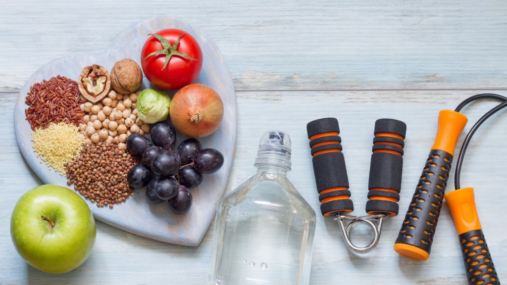 Fruits and nuts on a heart plate with workout gear and water