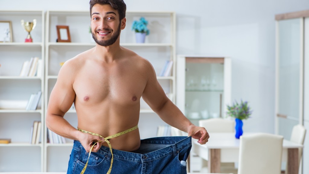 man with tape-measure around waist and extremely large pants