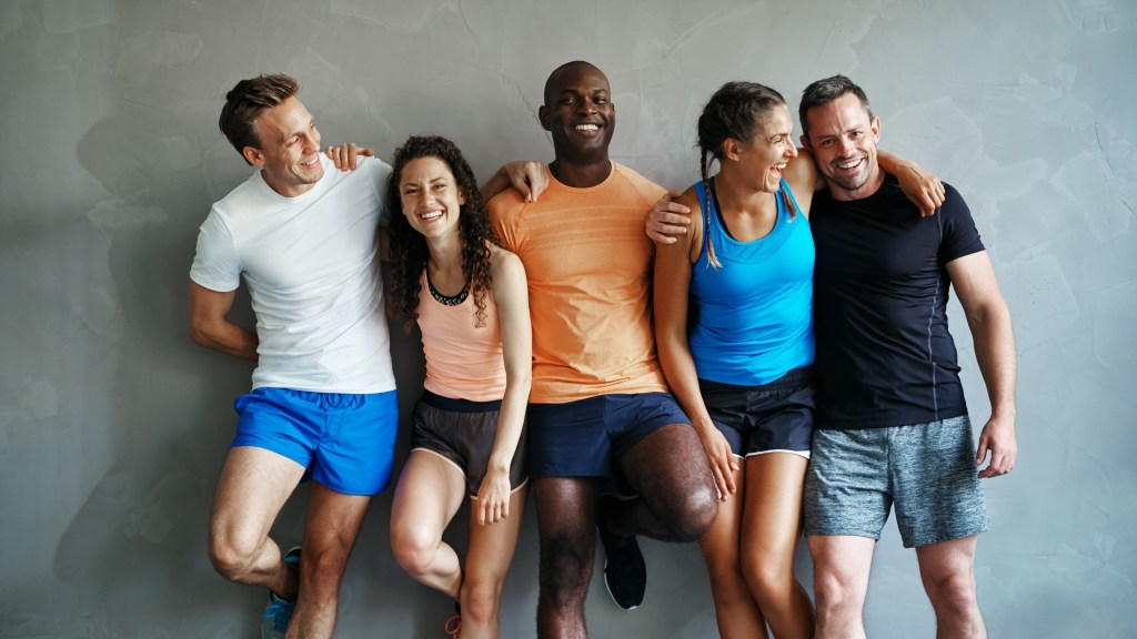group of people smiling dressed in workout gear