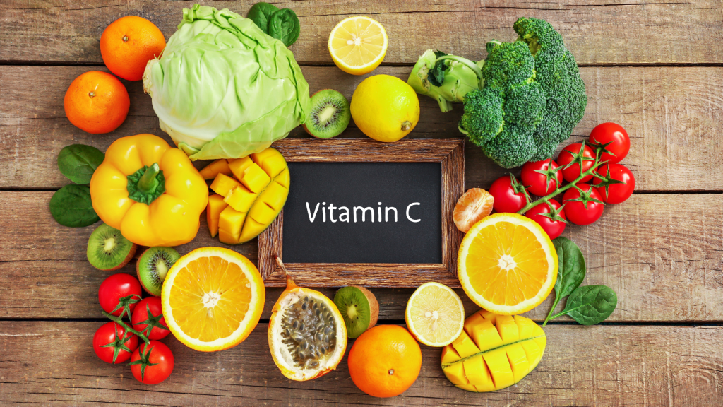 vitamin C written on chalkboard with sources (oranges, peppers, tomatoes, broccoli, etc).