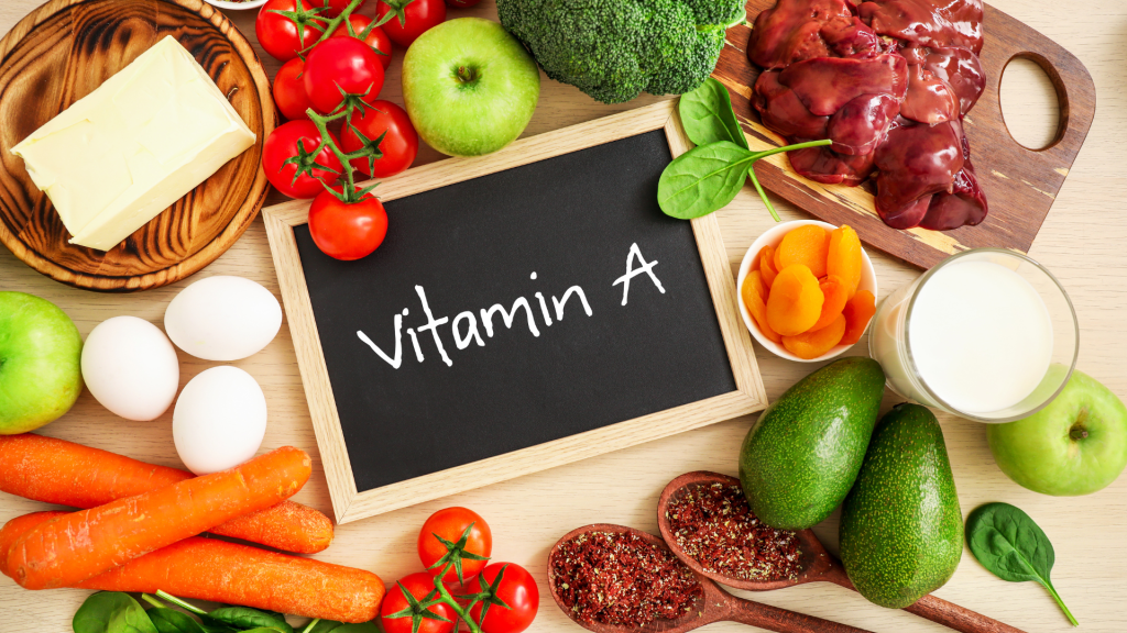 Vitamin A written on chalkboard with food sources including eggs, carrots, tomatoes, and more.