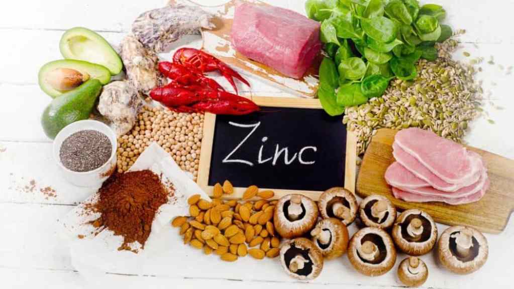 Assorted zinc-rich foods displayed with a chalkboard sign reading "zinc.