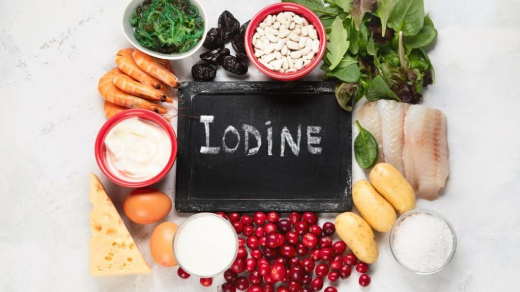 Various foods rich in iodine displayed around a chalkboard with the word "iodine" written on it.