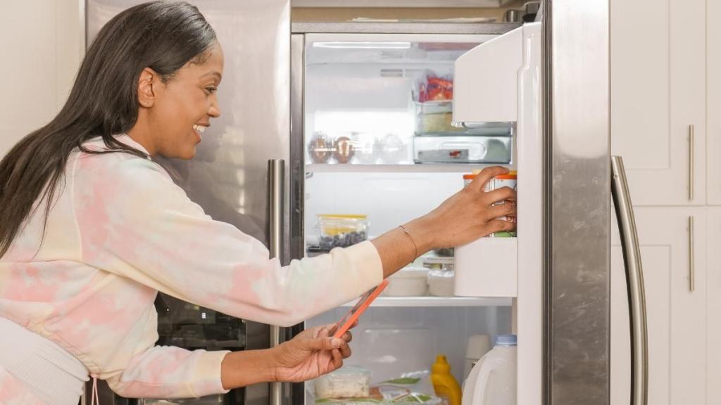 Woman reaching into the fridge.