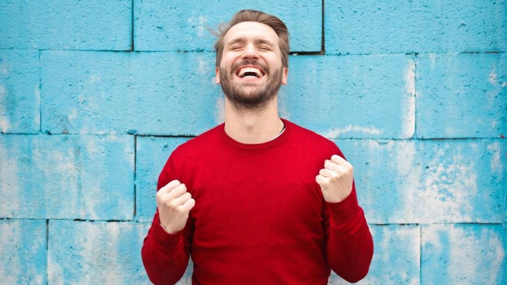 Excited man cheering against a blue background