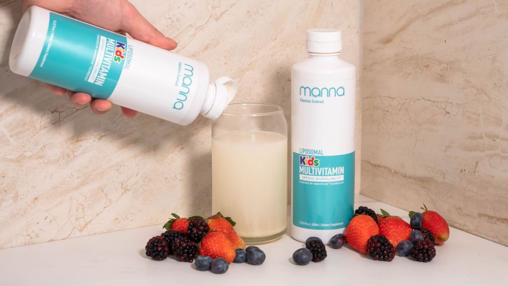 A hand pours Mama Kids Multivitamin into a glass. Two bottles are present with various berries arranged at the base.
