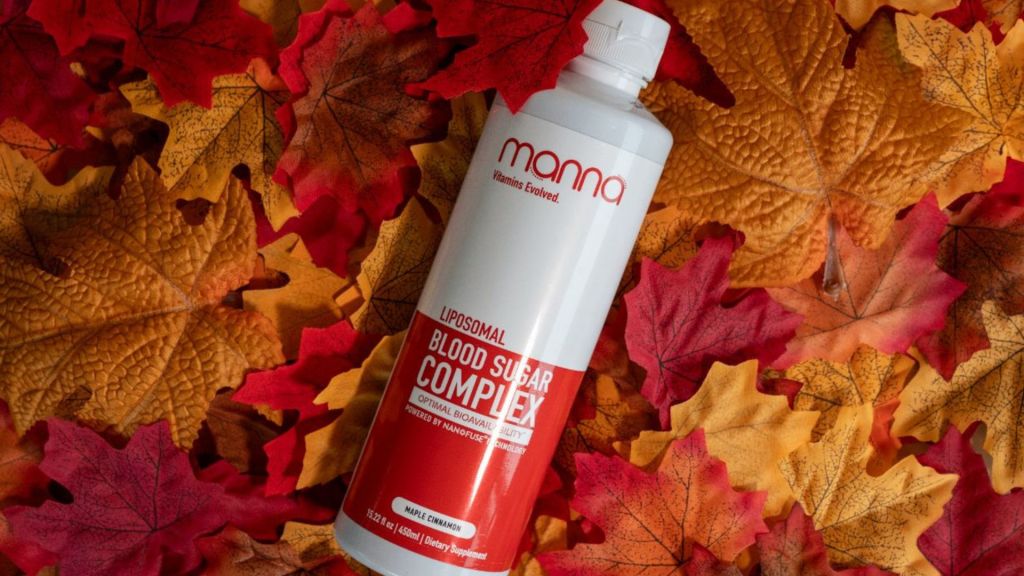 A bottle labeled "Manna Liposomal Blood Sugar Complex" is placed among colorful autumn leaves.