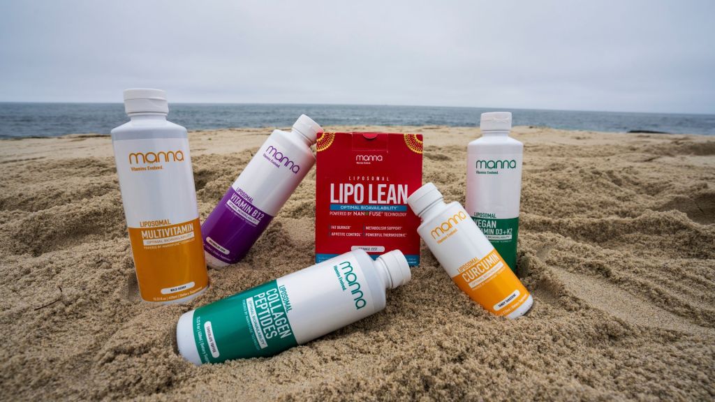 Bottles of health supplements and a box of Lipo Lean are arranged on a sandy beach with the ocean in the background.
