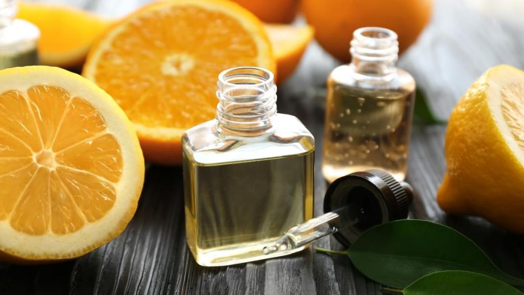 Bottles of oil extracts and dropper nearby, with orange halves.