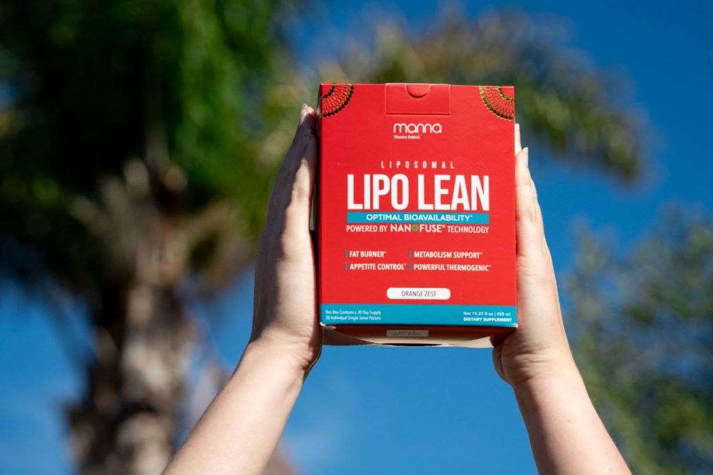 Hands holding a red "Lipo Lean" supplement box outdoors, with trees blurred in the background.